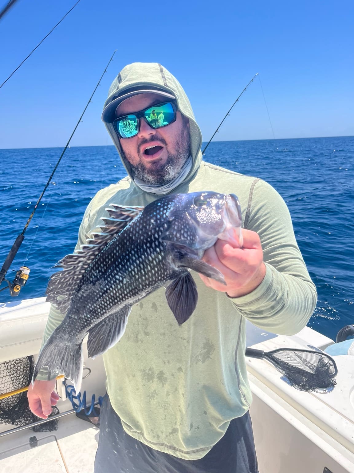 An angler with a black sea bass caught bottom fishing offshore of Hilton Head