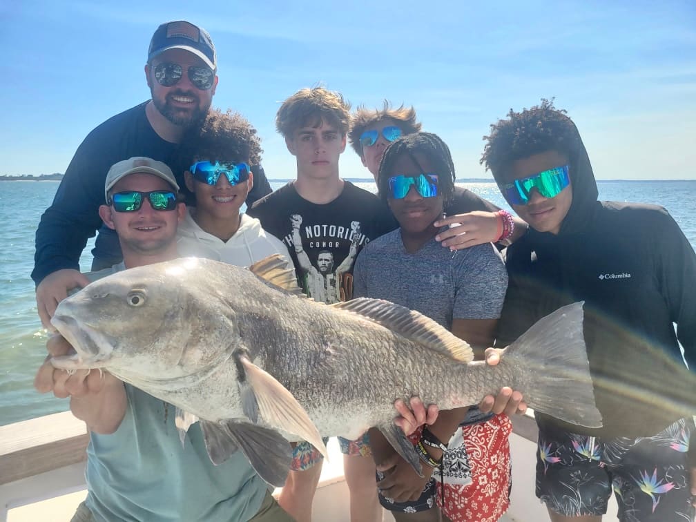 A group of young anglers and their captain with a big black drum aboard Southern Hook